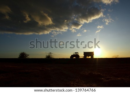 Summer landscape with a field and a tractor on a road