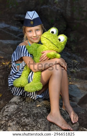 The girl in the marine cap with a toy frog