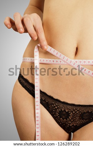 View of a slim stomach with measuring tape around it