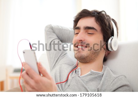View of a Young relaxed man listenning music in the sofa