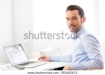 View of a Young business man working at home on his laptop