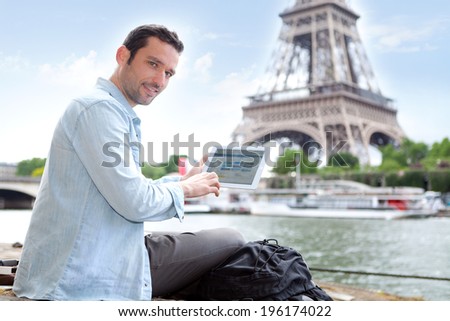 View of a Young attractive tourist using tablet in Paris, France