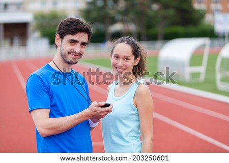 Sport coach training a young attractive woman on a stadium