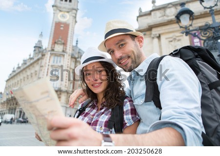 View of a Couple of young attractive tourists watching map