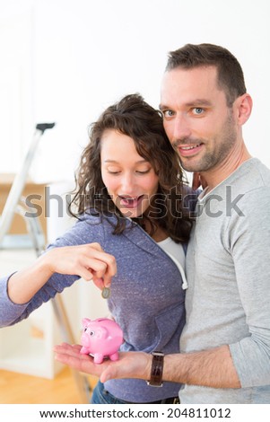 View of a Young couple saving money in a piggy bank
