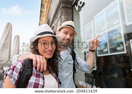 View of a Young happy couple in front of travel agency