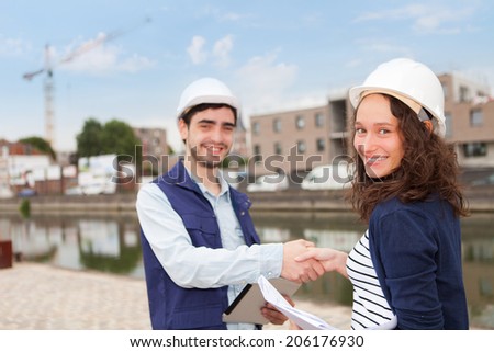 Architect woman and construction site supervisor shaking hands