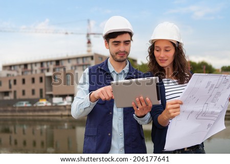Architect woman and construction site supervisor watching plans