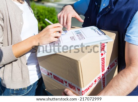 Detailed view of a customer signing delivery note