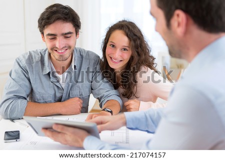 View of a young relaxed couple meeting a real estate agent