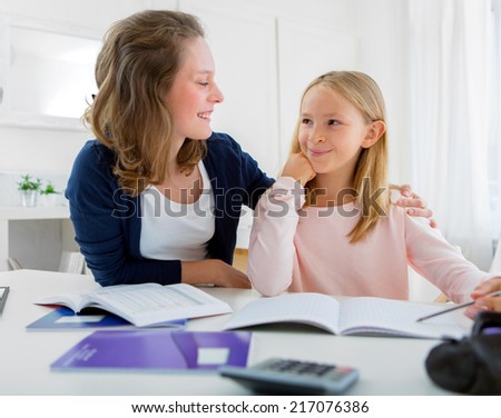 Portrait of a Woman helping out her little sister for homework
