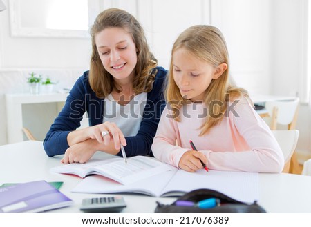 View of a Woman helping out her little sister for homework