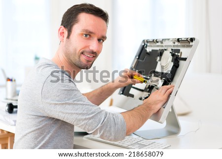 View of a Young attractive man repairing a computer