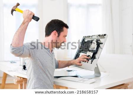View of a Young attractive man angry against computer