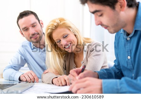 View of a young serious couple meeting a real estate agent