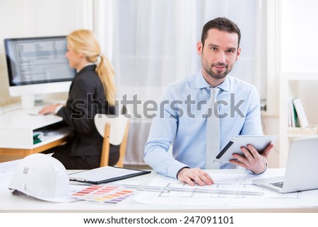 View of a Young attractive engineer working at the office
