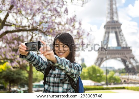 View of a Young attractive asian tourist in Paris taking selfie