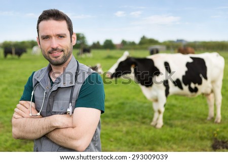 View of a young attractive veterinary in a pasture with cows
