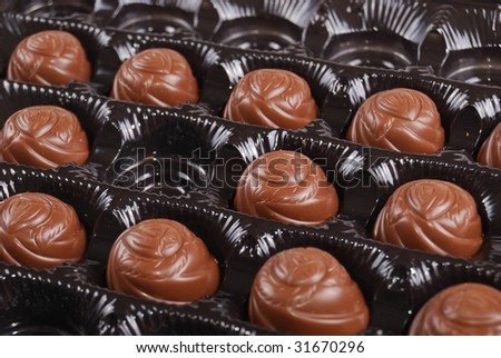 Chocolates in a box of black colour. A dessert.