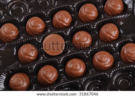 Chocolates in a box of black colour. A dessert.