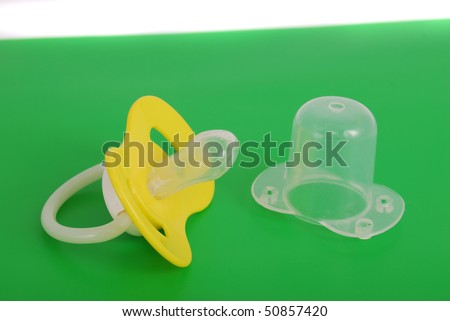 Children\'s dummy from plastic and rubber on a green background