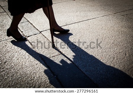 Elderly woman walking with cane