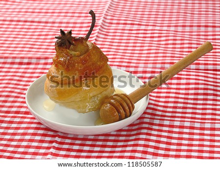 Dessert from a pear with honey in a puff test on a background a  checked table-cloth
