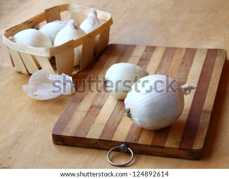 Two white onions and  white onions on a basket.