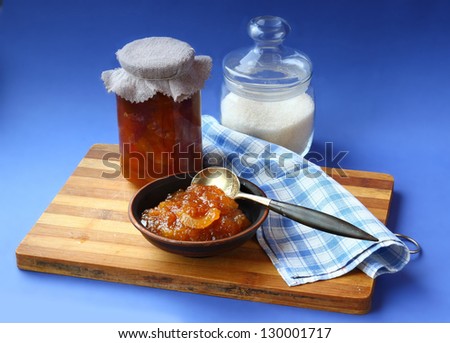 Jar of homemade jam from a quince and jar with sugar on a wooden table