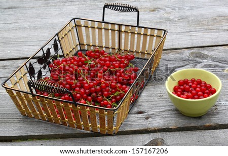 Currant berries and green cup with berries on a wooden table