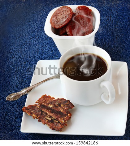 Homemade sweets from apples and nuts and a cup of coffee on dark-blue background
