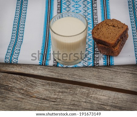 Glass of milk and rye bread on an embroidered towel