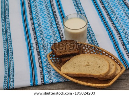 Glass of milk and rye bread on an embroidered towel