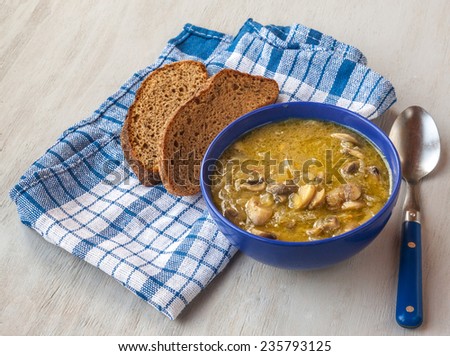 Vegan lenten mushroom soup in a blue plate and slices of rye bread
