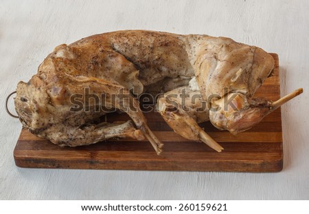 Baked rabbit meat on a cutting board on the kitchen table in the cooking process