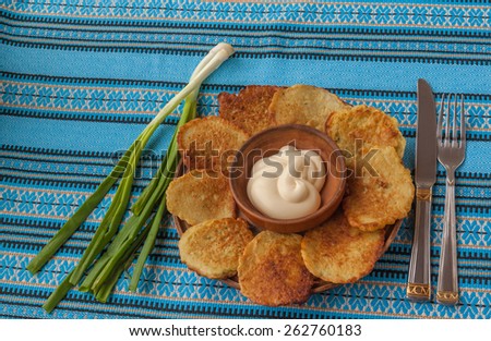 Traditional Ukrainian homemade potato pancakes potato and green onions with sour cream