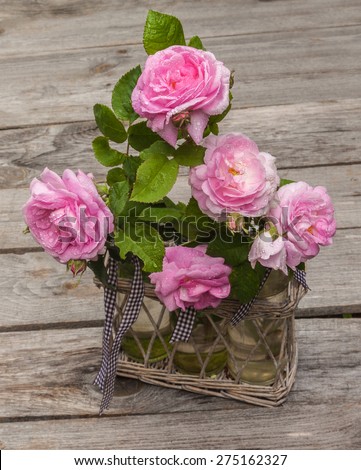 Bouquet of wild rose in vintage style on a wooden  table