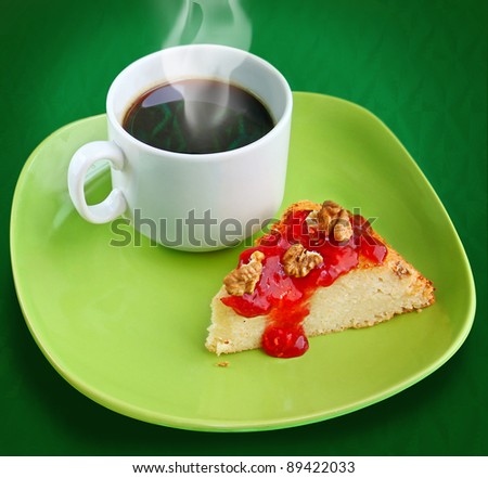 A cup of coffee with cheese cake with raspberry jam and nuts on green background