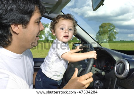 Father and son at the wheel. Learning to drive and having fun.