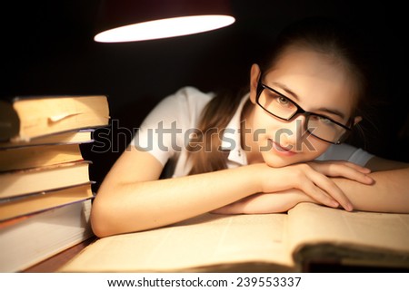 Young girl bored at reading under lamp