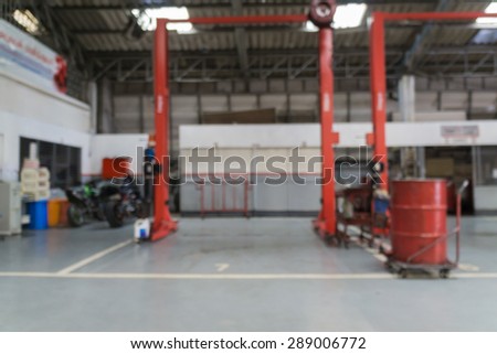Blurred of car technician repairing the car in garage background.