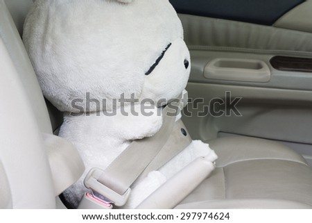 Safety first : doll buckled up with seatbelt inside the car.
