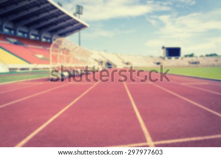 Blur of Red running tracks in sport stadium with retro filter effect