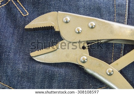 locking Pliers and lime put on jeans background.