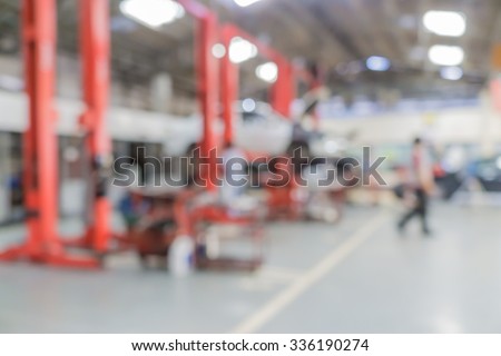 Blurred of car technician repairing the car in garage background, Interior of a car repair station.