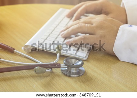 healthcare, hospital and medicine concept - male doctor typing on the keyboard,Doctor type keyboard with stethoscope,selective focus,vintage color.