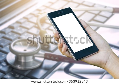 Women  Hand holding smart phone with online device on screen over blur Medical Stethoscope Resting on Desk,emergency call concept.