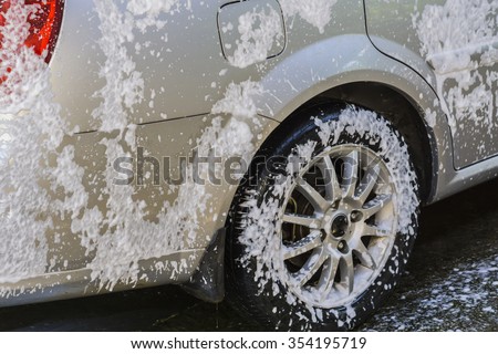 car washing by hand using a foam preparation for polishing,cars in a carwash,selective focus