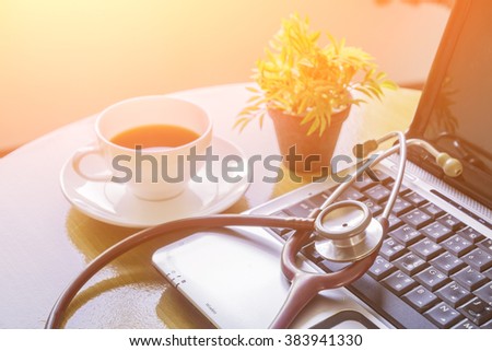 Stethoscope on laptop keyboard,stethoscope on the keyboard of pc,Medical Stethoscope Resting on Desk,relax time doctor,selective focus,vintage color.morning light
