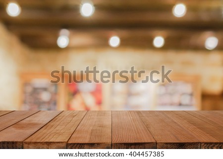Empty brown wooden table and Coffee shop interior with some people meeting blur background with bokeh image, for product display montage,can be used for montage or display your products